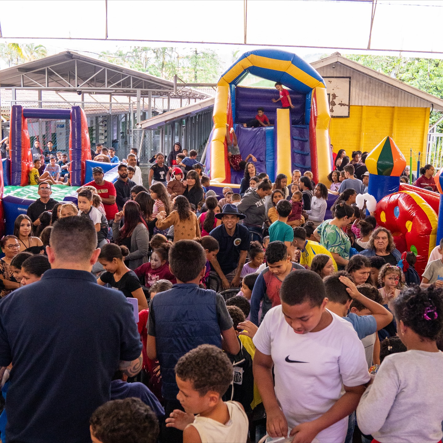Conheça a ADSMI Grande evento com muitas crianças brincando e brinquedos ao fundo.